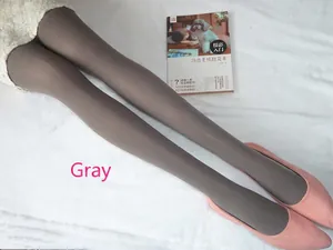 Collants gris en velours portés avec des ballerines roses sur fond en peluche