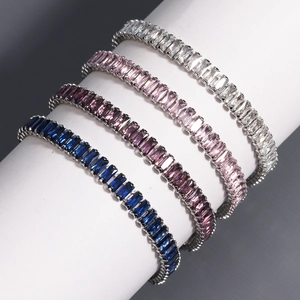 Close-up of four-color zircon tennis bracelets with emerald-cut stones on a white stand