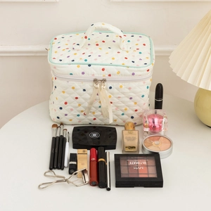 Close-up of quilted cotton makeup bag with colorful polka dots and travel toiletries