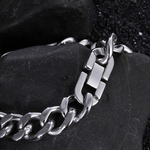 Close-up of hip hop silver Cuban chain with diamond square buckle on dark stone