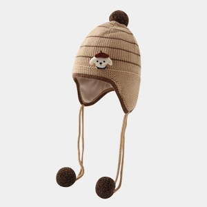 Close-up of a striped knit puppy hat for kids with fluffy pom-poms and soft inner lining