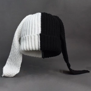 Close-up of contrast knit hat featuring long bunny ears and black and white textures