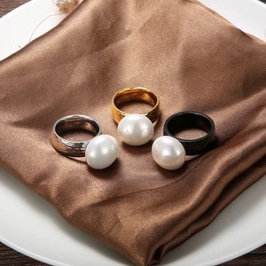 Three hammered texture rings with pearls in gold, silver and black on brown satin fabric