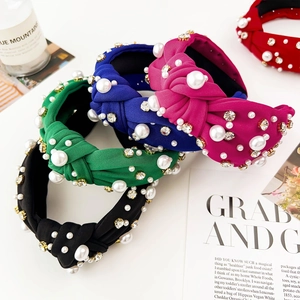 Detailed top view of luxury knotted headbands with sparkling rhinestones and pearls