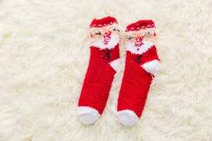 Detail of red Christmas socks with Santa Claus embroidery in soft coral fleece fabric