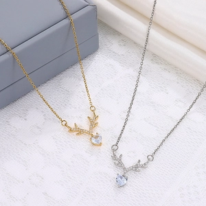 Detailed view of elk horn necklaces with heart crystal and tiny pearls in gold and silver
