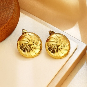 Gros plan macro de boucles d'oreilles dorées avec texture brossée radiale élégante