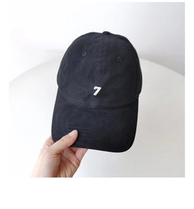 Close-up of black cotton baseball cap showing white embroidered number 7 and fabric texture