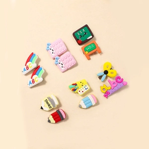 Close-up of school-themed rubber hair clips including blackboard and pencil designs