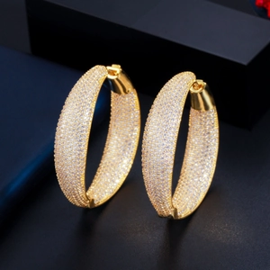 Elegant gold plated hoop earrings with micro paved zircon stones on a dark background