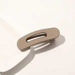Close-up of matte khaki duckbill hair clip with minimalist hollow geometric design