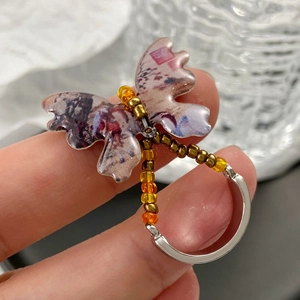 Artistic fan-shaped earrings with butterfly ink print and golden beaded detail