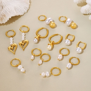 Elegant gold plated tassel pearl earring collection on a textured minimalist background