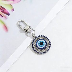 Detail of blue Evil Eye keychain with silver gear border and sparkling rhinestones