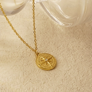 Vintage gold compass necklace with white rhinestone center on minimalist chain