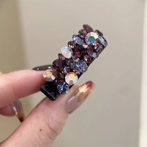 Détail d'une petite pince à cheveux avec des strass étincelants bleus et violets