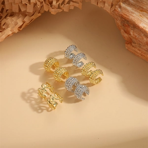 Minimalist 14K gold and silver plated copper bead ear cuffs with leaf design on wooden props