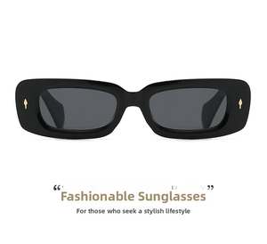 Detailed shot of rectangle sunglasses with golden arrow metal accents on black frames