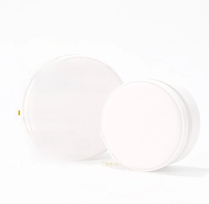 Detailed view of two white mini round jewelry boxes with silver metal zipper closure