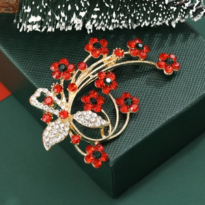 Elegant Christmas flower and butterfly brooch with red rhinestones on festive gift box