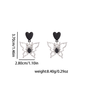 Détail de boucles d'oreilles papillon cyberpunk avec clous cœur noir et dimensions