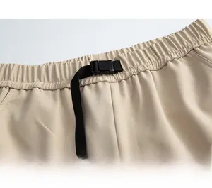 Detail of adjustable waist with elastic band and nylon buckle on cargo pants