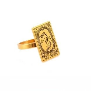 Macro shot of gold tarot The World card ring showing intricate goddess and wreath details