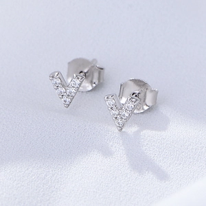 Macro shot of V-shaped S925 silver stud earrings with sparkling zircon inlay