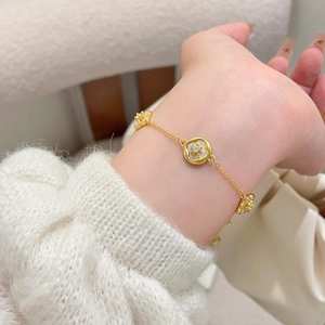 Bracciale a fiori placcato oro 18 carati con zircone e madreperla al polso del modello