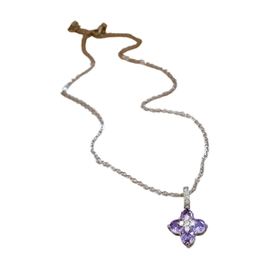 Collier en argent avec pendentif trèfle violet et zircons blancs sur fond blanc épuré