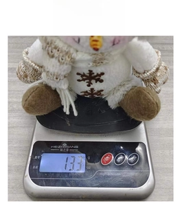 Détail d'un bonhomme de neige en peluche avec broderie flocon et affichage du poids