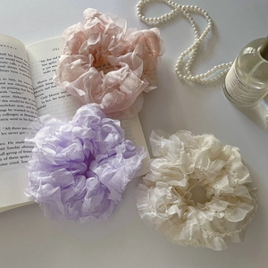 Chiffon scrunchies in pink, purple and beige set displayed on an elegant desktop