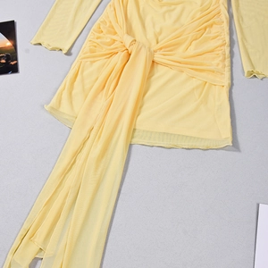Dettaglio dell'abito corto in mesh giallo con maniche lunghe e design arricciato