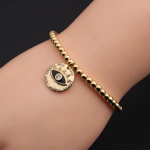 Macro detail of gold-plated evil eye charm bracelet with sparkling zircon stones
