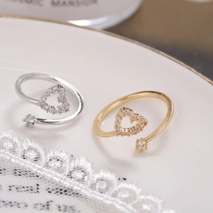 Adjustable heart-shaped zircon rings in gold and silver finish on a decorative plate