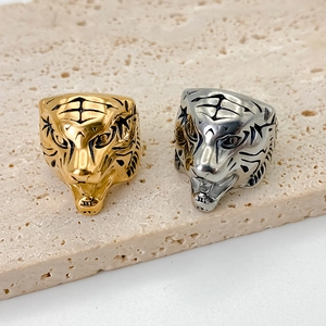 Dettaglio ravvicinato di anelli a testa di tigre in acciaio inox oro e argento