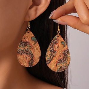 Close-up of bohemian cork drop earring featuring vintage ethnic floral patterns on model
