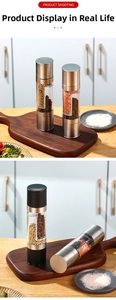 Close-up of a dual-head stainless steel pepper grinder in a modern kitchen setting