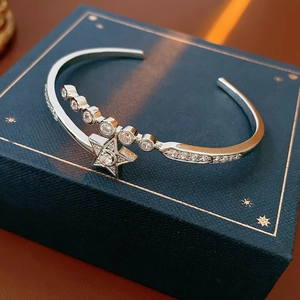 Macro shot of silver star bangle with shimmering zircon stones and open adjustable design
