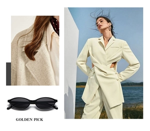 Detailed view of cream tailored suit fabric texture with black oval frame sunglasses