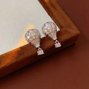 Détail des boucles d'oreilles montgolfière en argent avec zircons sur boîte à bijoux