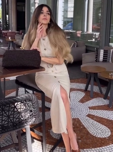 Grande pochette intrecciata marrone scuro presentata su un tavolo in un caffè all'aperto