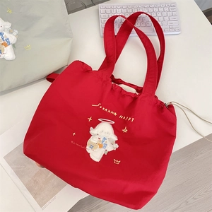 Detail view of the red canvas tote bag with white angel lamb embroidery and star patterns