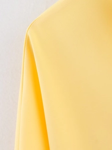 Macro shot of bright yellow safari shirt fabric showing fine twill texture and weaving