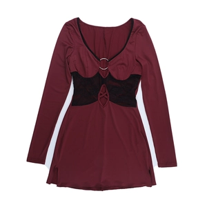 Close-up of wine red dress featuring black lace patchwork, metal ring, and cutout waist