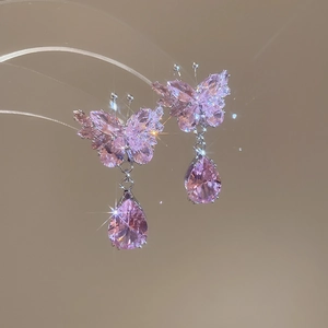 Macro shot of sparkling pink zircon butterfly and teardrop tassel earrings for women