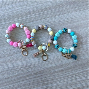 Detailed flat lay of colorful silicone pumpkin bead bracelets with tassels and metal clasps