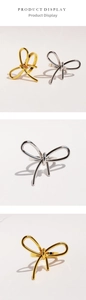 Detail view of modern metallic bow-knot rings in polished gold and silver finishes