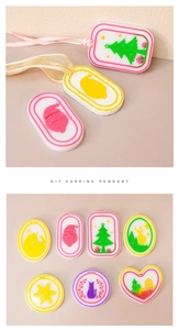 Flat lay of colorful DIY Christmas resin earring pendants with trees and snowflakes