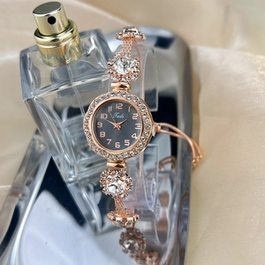 Detail of rose gold adjustable bracelet watch with crystal bezel and black numeral dial
